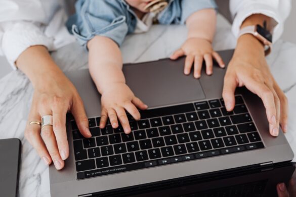 Mom on laptop baby hands on keyboard